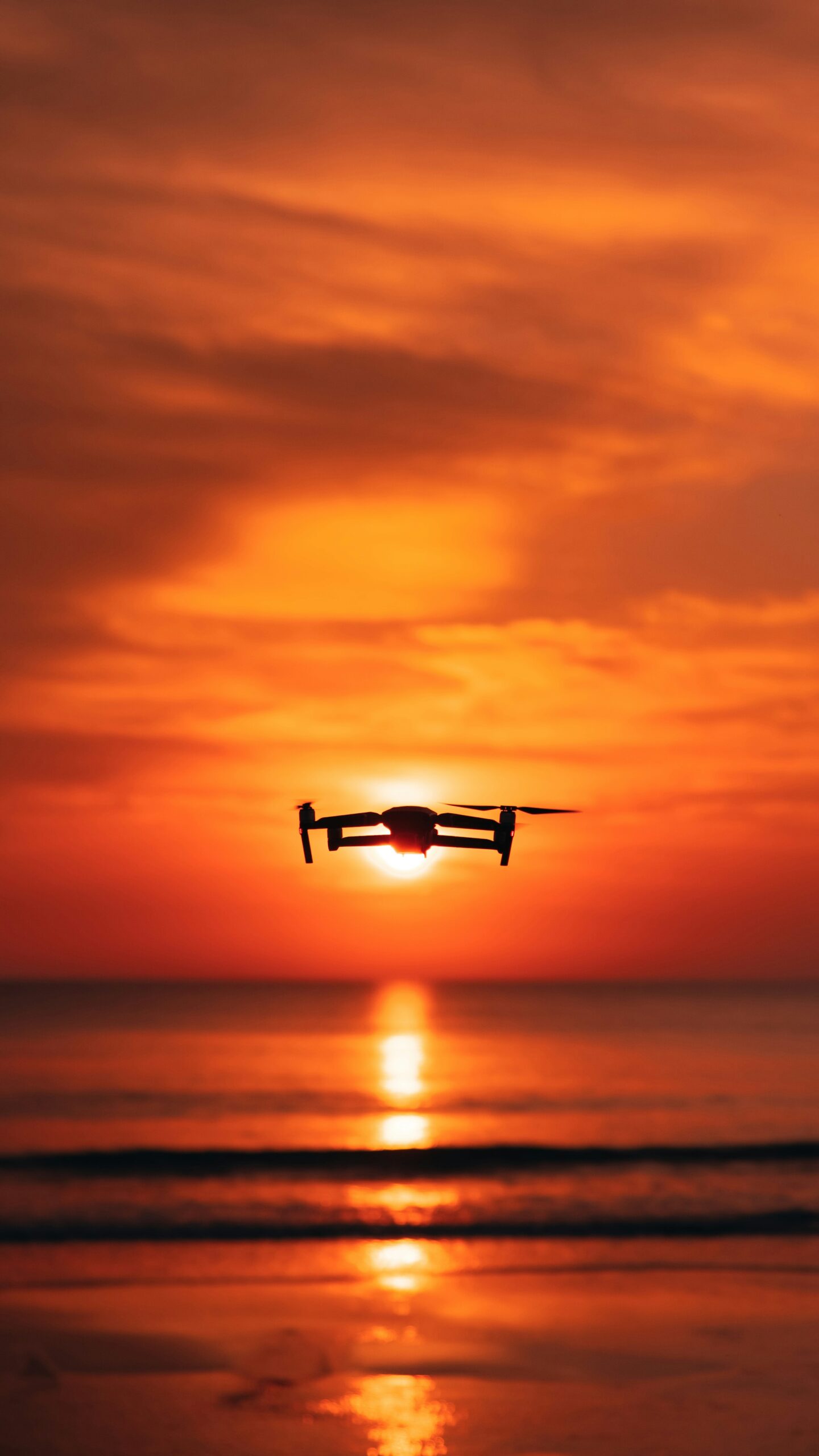 Aviator holding drone at sunset